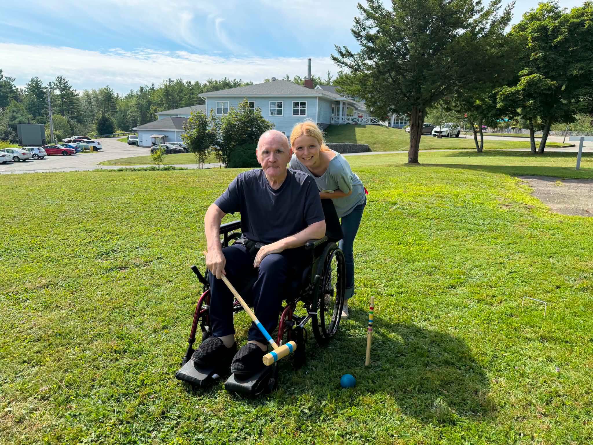 Resident with caregiver playing croquet