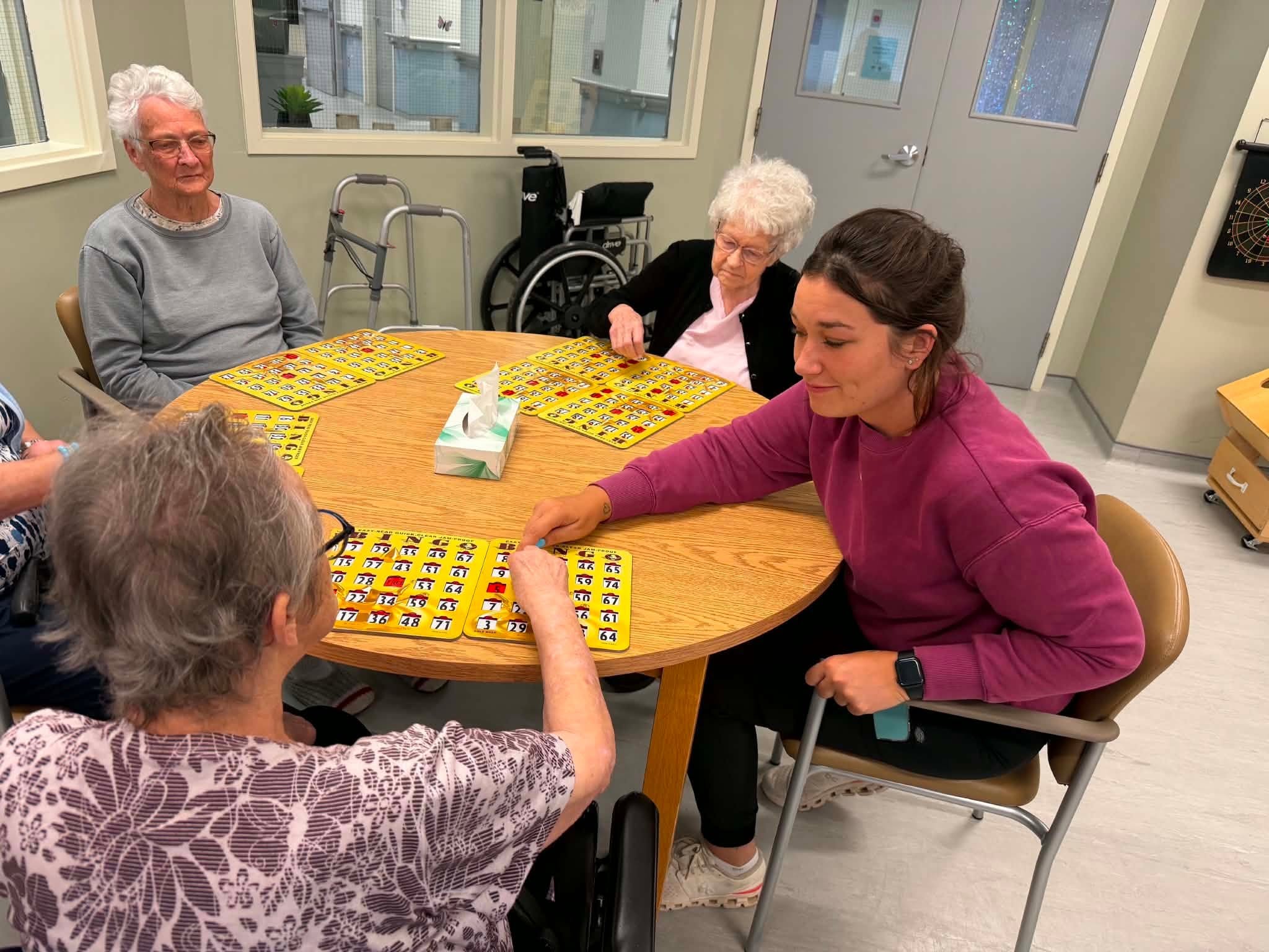 Staff assisting resident with bingo card